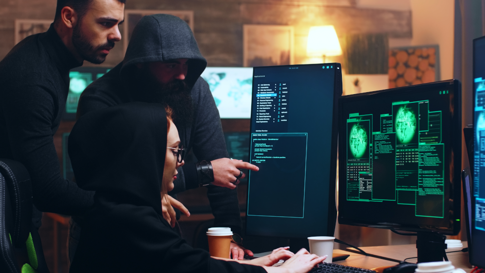 Cyber criminals attempting to hack into a computer system, representing dark web cyber threats and cybersecurity vulnerabilities.
