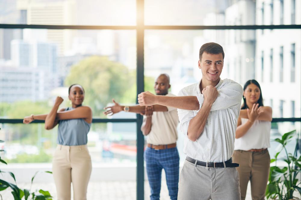 Employees prioritize physical well-being by taking a break to stretch, fostering a healthy workplace culture that encourages movement and supports employee wellness initiatives.
